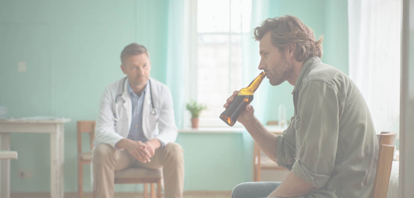 Мужчина сидит на стуле и пьет пиво на приеме у врача